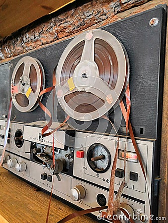 Old broken reel. old music center Studio tape recorder. The tape is wound on a reel bobbin Editorial Stock Photo